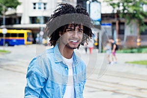 Mexican young adult man with long curly hair outdoor in city