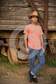 Mexican Young Man Posing in Front of a Wooden Old Train Wagon