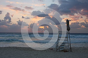 Mexico - Cancun - white sandy beach with a tall wooden beach. Beautiful sunrise over the sea. The sun`s rays shine through the