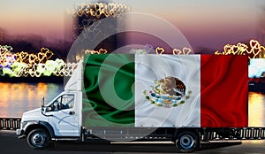 Mexico flag on the side of a white van against the backdrop of a blurred city and river. Logistics concept