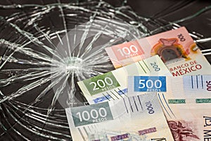 Mexico Money, Pesos Problems, Weakening of Mexican Currency, Bundle of Mexican Money on Broken Glass Background,
