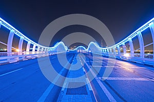 Meydan Bridge and street road or path way on highway with modern architecture buildings in Dubai Downtown at night, urban city at