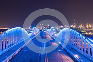 Meydan Bridge and street road or path way on highway with modern architecture buildings in Dubai Downtown at night, urban city at