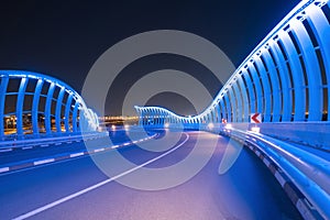 Meydan Bridge and street road or path way on highway with modern architecture buildings in Dubai Downtown at night, urban city at