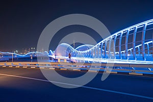 Meydan Bridge and street road or path way on highway with modern architecture buildings in Dubai Downtown at night, urban city at