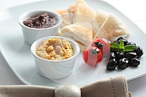 Meze with tomato, olives, and pita bread photo