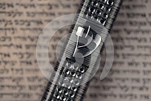Mezuzah case laying on blurred parchment with Jewish prayer Shema Yisrael in hebrew, mezuzah commandment photo