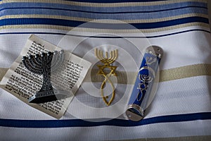 the Mezuzah scrolls and the Minurah on a beautiful white tallit