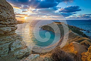 Mgarr, Malta - Panorama of Gnejna bay, the most beautiful beach in Malta at sunset photo