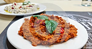 Mhamara Muhammara very spicy red pepper dip served on a table in a traditional Syrian restaurant.