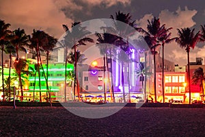 Miami Beach Ocean Drive hotels and restaurants at sunset. City skyline with palm trees at night. Art deco nightlife on