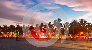 Miami Beach Ocean Drive hotels and restaurants at sunset. City skyline with palm trees at night. Art deco nightlife on