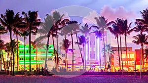 Miami Beach Ocean Drive hotels and restaurants at sunset. City skyline with palm trees at night. Art deco nightlife on