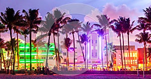 Miami Beach Ocean Drive hotels and restaurants at sunset. City skyline with palm trees at night. Art deco nightlife on photo