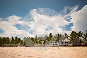 Miami Beach volleyball net courts on the sand. Long exposure photo shot with motion blur imn palm trees and clouds