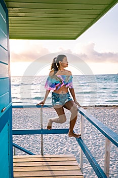 Miami beach, woman at an lifeguard hut at Miami beach Florida, girl in dress on the beach with bikini