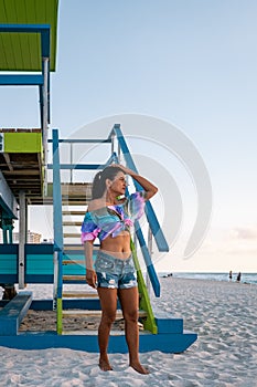 Miami beach, woman at an lifeguard hut at Miami beach Florida, girl in dress on the beach with bikini