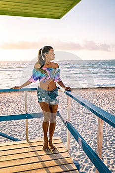 Miami beach, woman at an lifeguard hut at Miami beach Florida, girl in dress on the beach with bikini