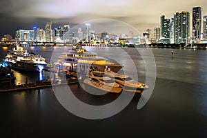 Miami city night. Beautiful colorful city of Miami Florida skyline and bay with night clouds.