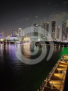 Miami city skyline panorama at dusk with urban skyscrapers and bridge over sea