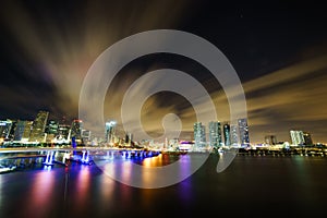 Miami city skyline panorama at dusk with urban skyscrapers and bridge over sea with reflection