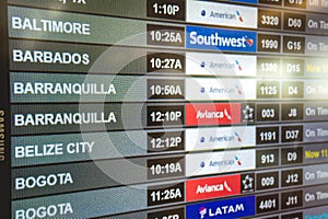 Miami, Florida - Departure board at Miami International Airport displaying flights to various destinations with