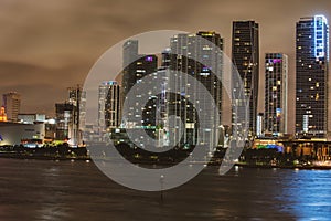 Miami Florida at sunset, skyline of illuminated buildings and Macarthur Causeway bridge. Miami night downtown, city