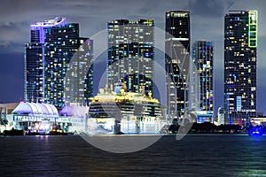Miami night downtown. Cruise ship in the Port of Miami at sunset with multiple luxury yachts. Night view of cruise