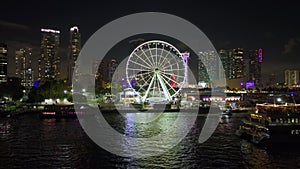 Miami Observation Wheel at Bayside Marketplace with reflections in Biscayne Bay and illuminated skyscrapers of