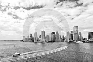 Miami skyscrapers with blue cloudy sky, boat sail, Aerial view