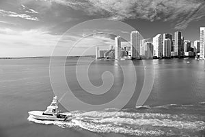 Miami skyscrapers with blue cloudy sky, boat sail, Aerial view