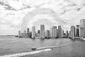 Miami skyscrapers with blue cloudy sky, boat sail, Aerial view