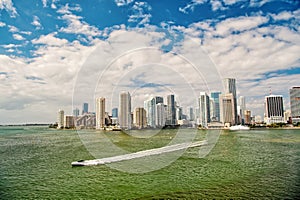 Miami skyscrapers with blue cloudy sky, boat sail, Aerial view