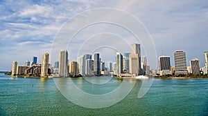 Miami skyscrapers with blue cloudy sky, boat sail, Aerial view