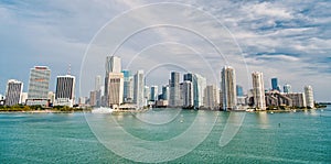 Miami skyscrapers with blue cloudy sky, boat sail, Aerial view