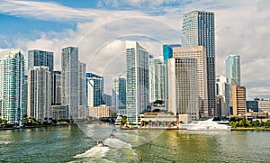 Miami skyscrapers with blue cloudy sky, boat sail, Aerial view