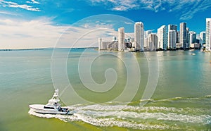 Miami skyscrapers with blue cloudy sky, boat sail, Aerial view