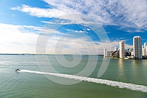 Miami skyscrapers with blue cloudy sky, boat sail, Aerial view