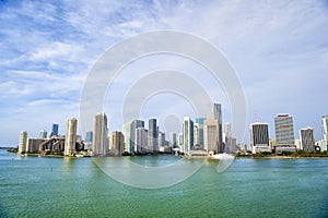Miami skyscrapers with blue cloudy sky, boat sail, Aerial view