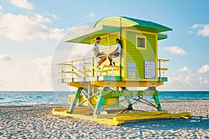 Miami south beach Florida, couple by lifeguard hut during Sunrise Miami Beach, men and woman on the beach