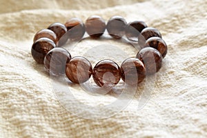 Mica rutilated quartz bracelet on fabric background.