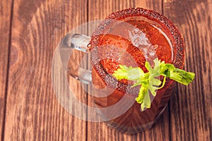 Michelada beer with tomato juice. Clamato with beer on wooden table. Mexican drink. Mexican food photo