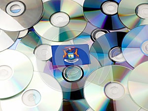 Michigan flag on top of CD and DVD pile on white