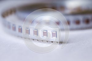 Micro Electronics Conceptual. Closeup of Tape with New SMD or Surface Mount Inductance Components in Tape Together On White