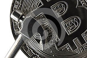 Micro hammer on the front side of the silver bitcoin. Close-up.