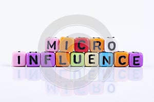 MICRO INFLUENCE word block concept on white reflection table