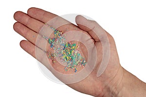 Micro plastic on a man`s hand, top photo. Dots of colored plastic on the hand