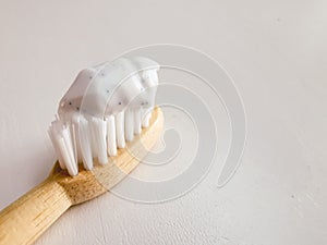 Micro plastic particles in a smear of toothpaste on a wooden toothbrush