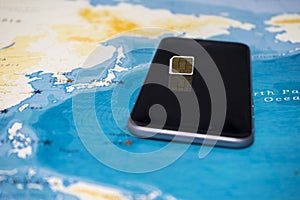 Micro SIM card and smartphone on the world map