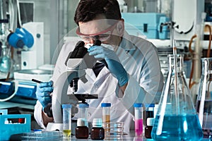 Microbiologist analyzing sample in the microscope